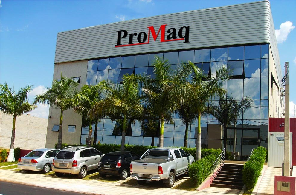 Fachada da Promaq em Boituva, SP, com o logotipo da empresa, vidros e palmeiras